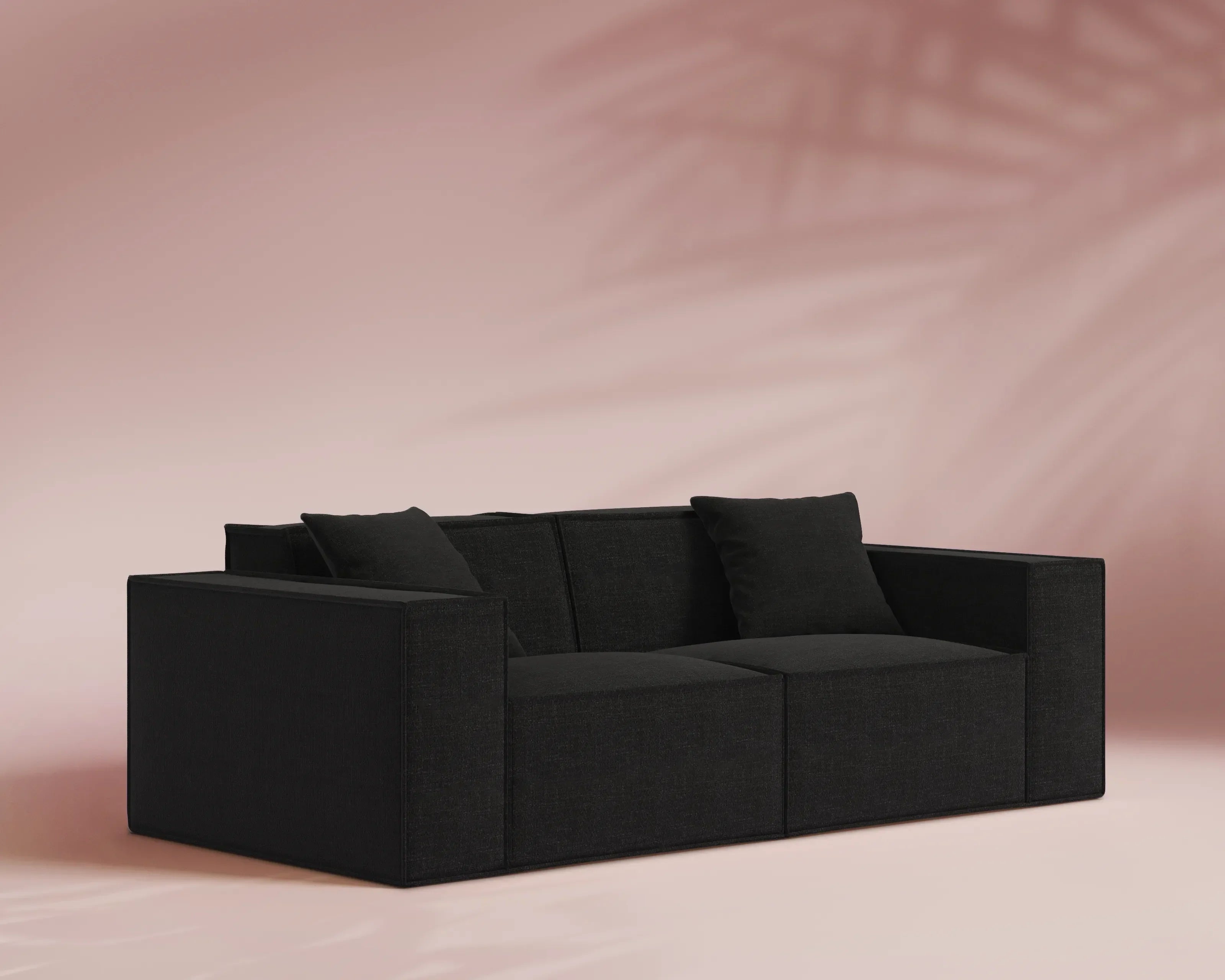 Black sofa against a pink background