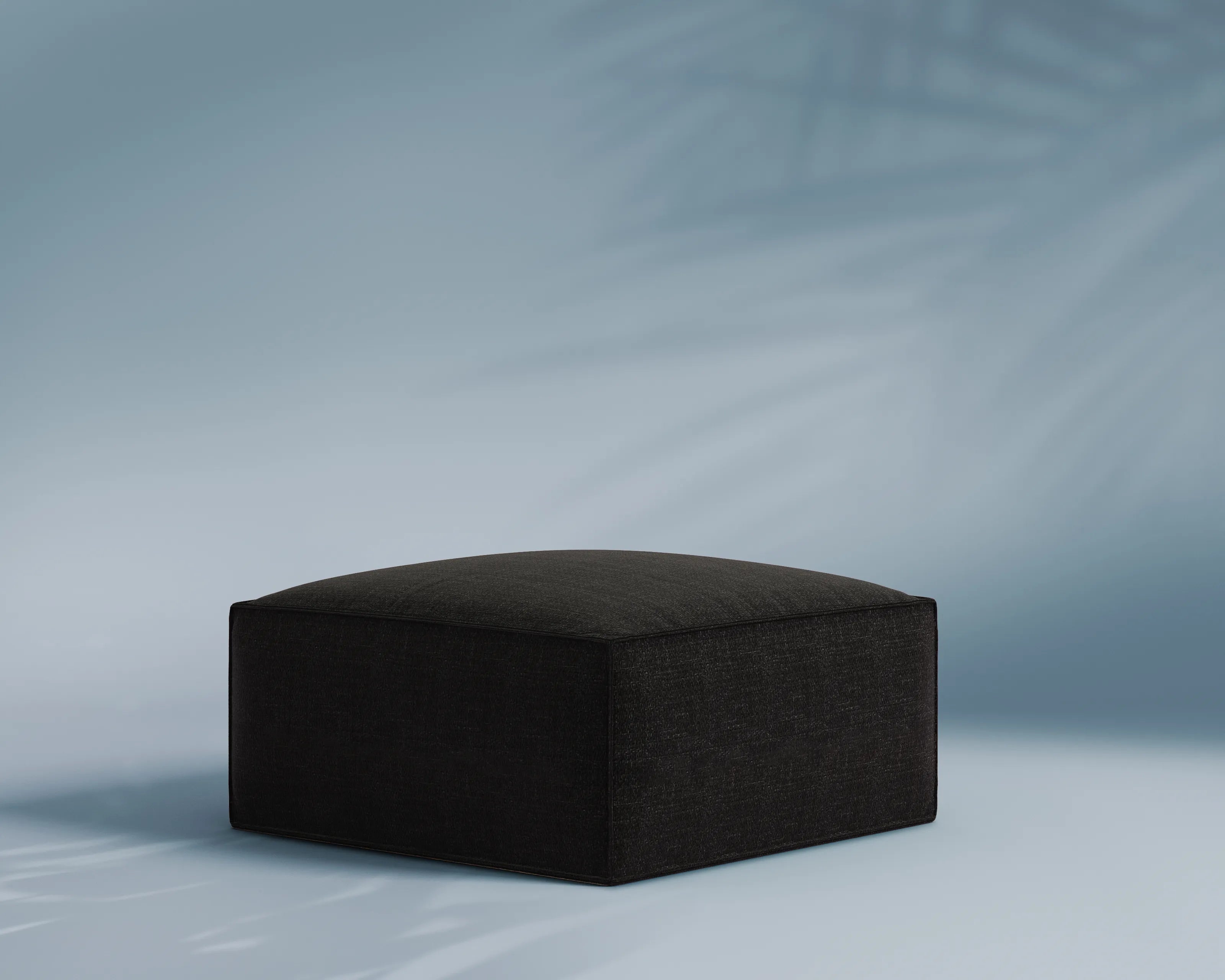 Black cube-shaped ottoman on a light gray background