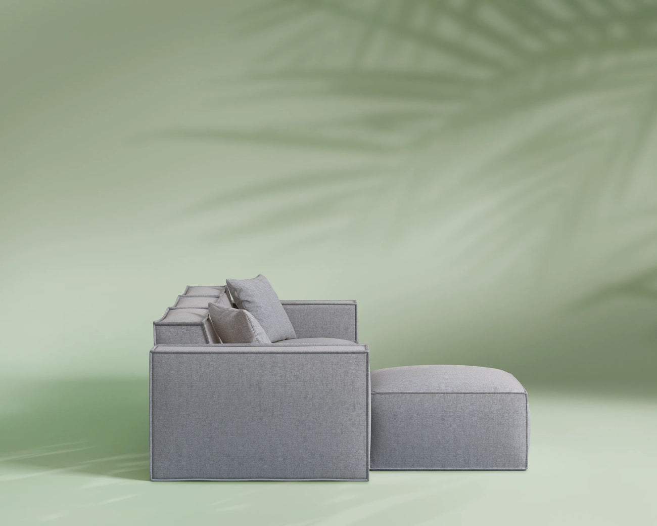 Gray sofa with cushions on a light green background