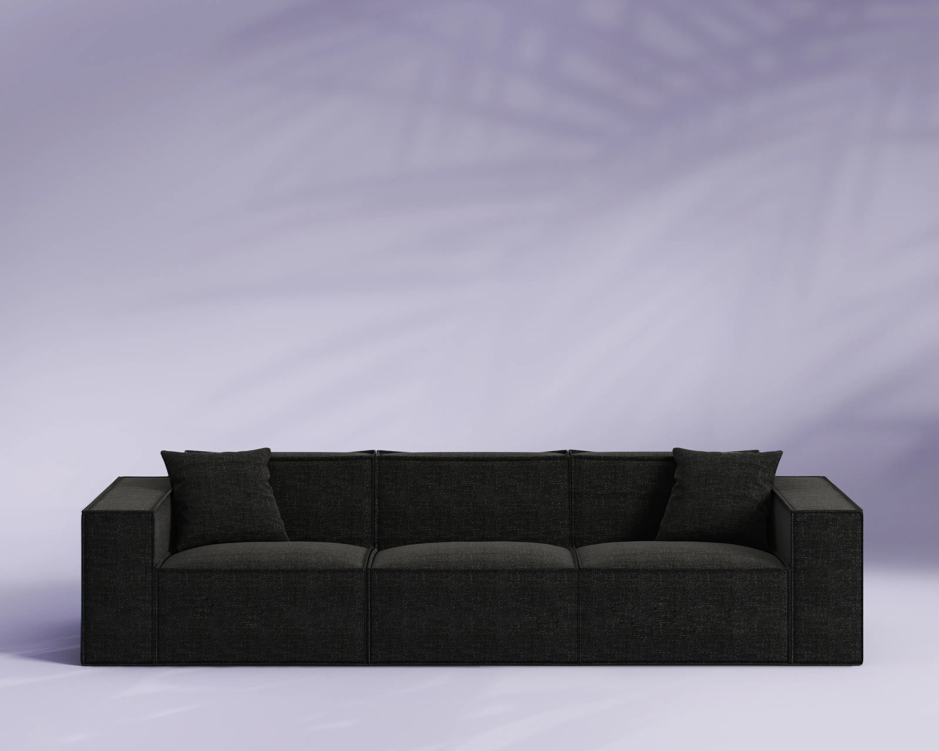 Black sofa against a light purple background