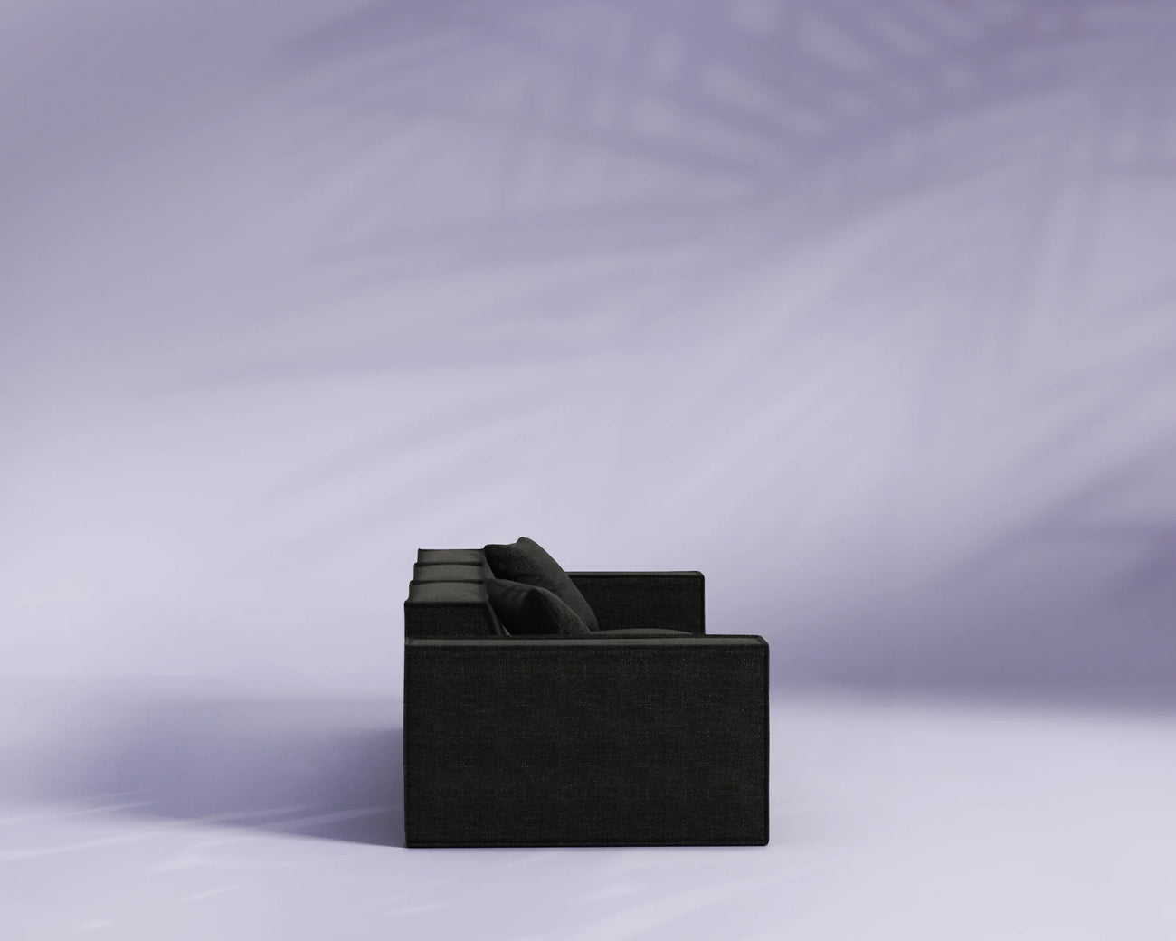 Black sofa against a light purple background