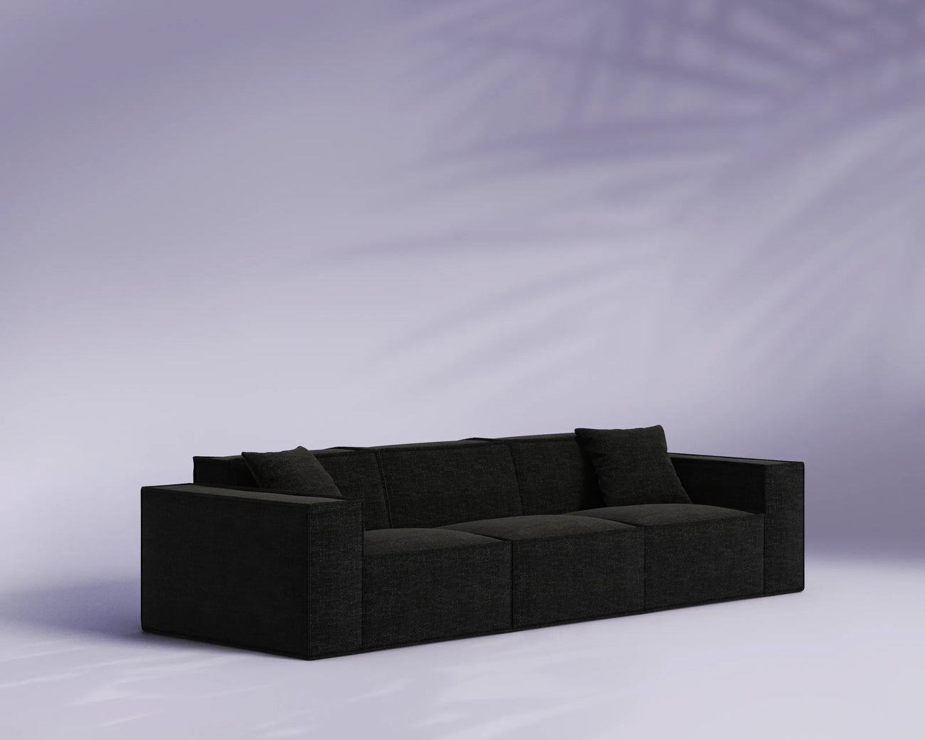 Black sofa against a light purple background