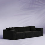 Black sofa against a light purple background