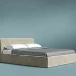 Beige bed with gray bedding against a teal background